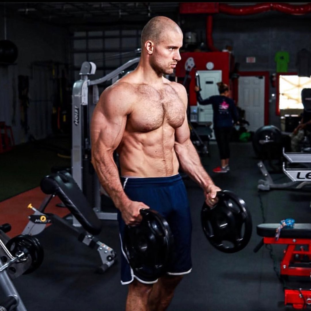 Andrei Sharkevich in the gym holding weight plates